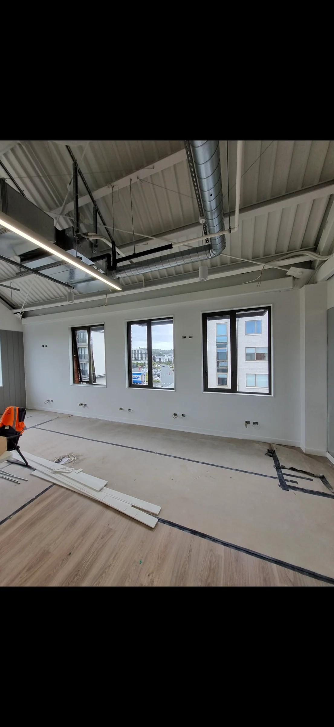 Fit-out progress: painted window wall and exposed ceiling at Reformer Pilates