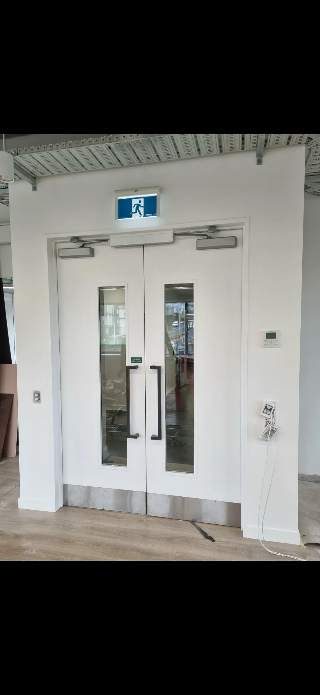 Fit-out progress: painted double doors, frames and surrounding wall